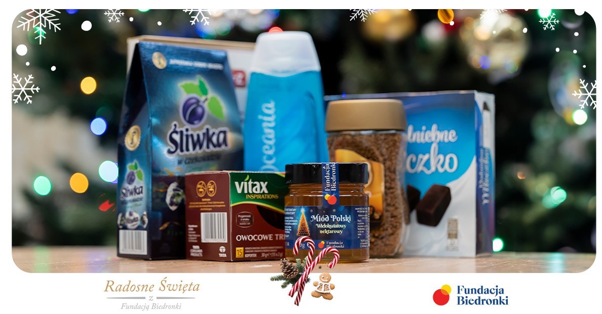 Obrazek przedstawia produkty: czekoladki, miód, herbata, kawa, żel pod prysznic, w ramce z logo Fundacji Biedronki i z podpisem Radosne święta.